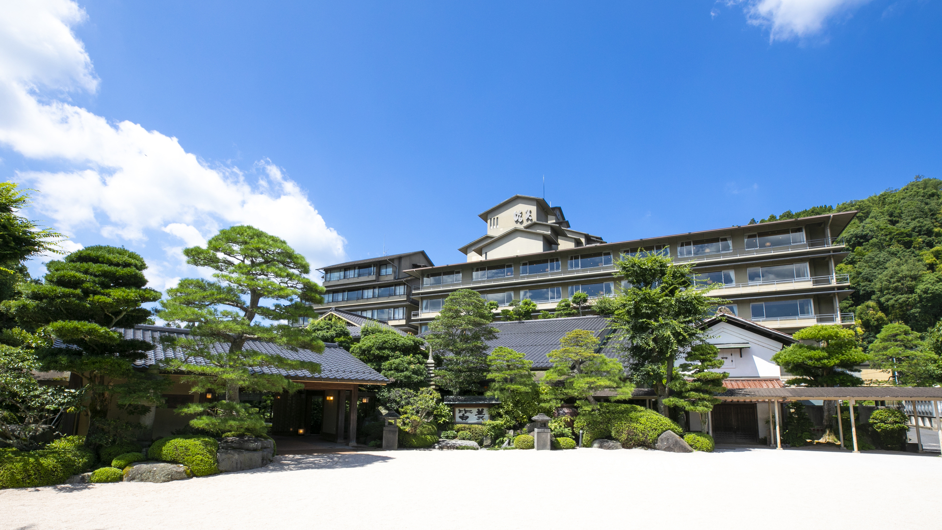 佳翠苑 皆美の外観。手入れされた松の庭の奥に建つ和風建築の旅館