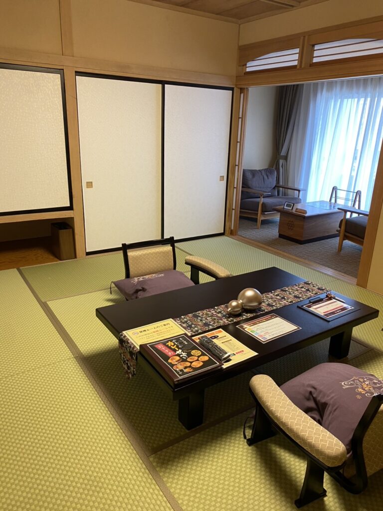 あさやの和洋室。手前に座卓を置いた和室、奥にソファとテーブルの洋間が続く